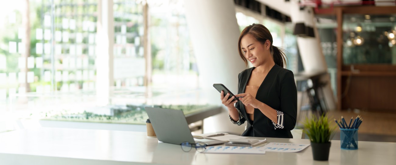 Business asian woman using mobile phone during checking an email