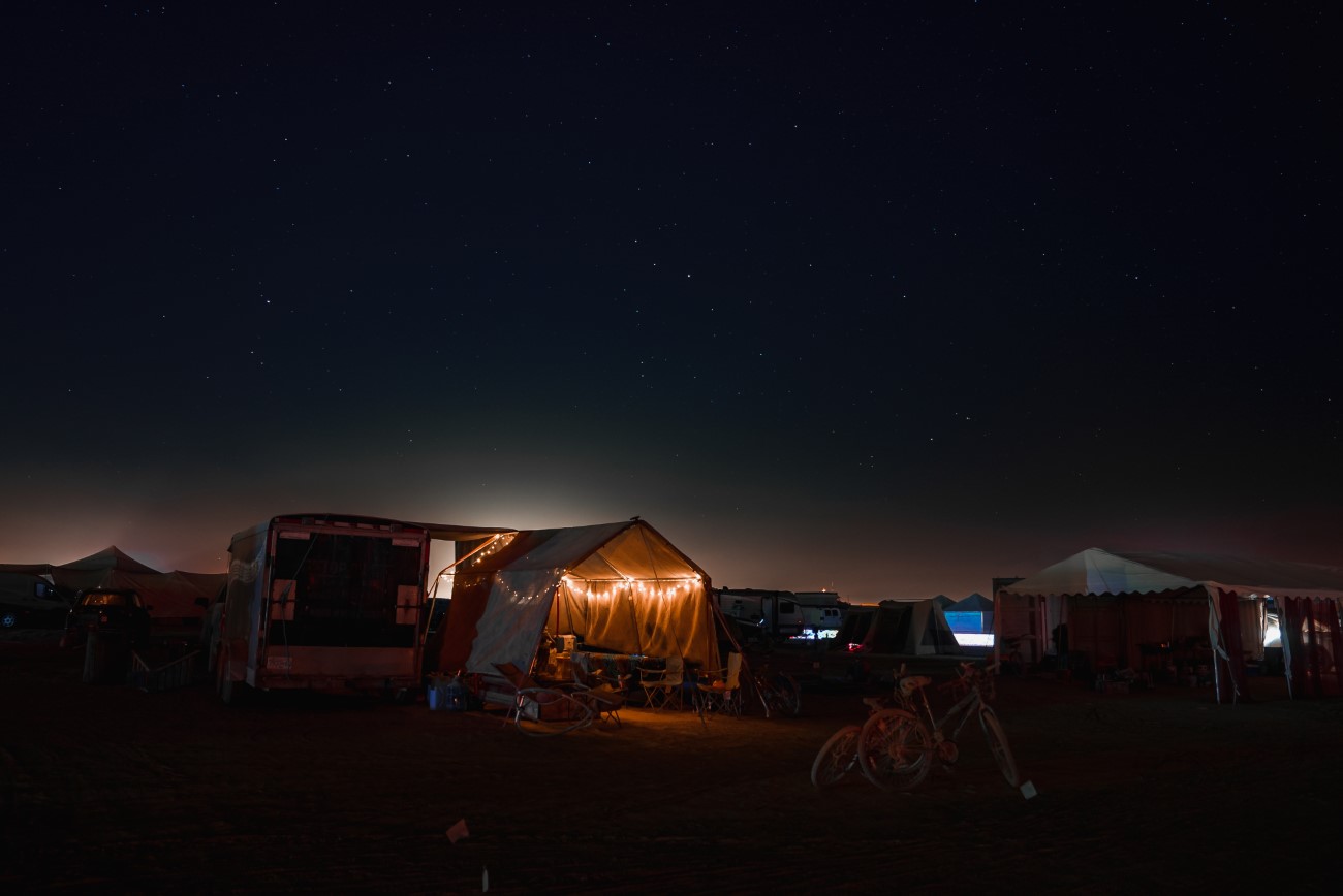 People walking towards sunset at a festival in the desert