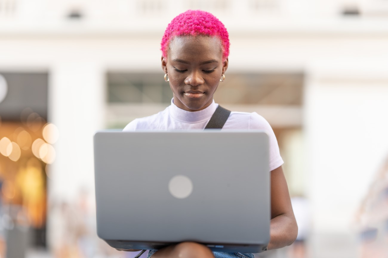 Portrait of a young african woman using the laptop outdoors